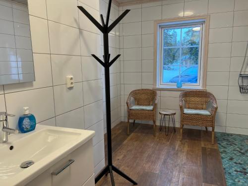 韦姆达伦Vemdalsskalet huset Myltan的一间带水槽和两把椅子的浴室以及窗户。