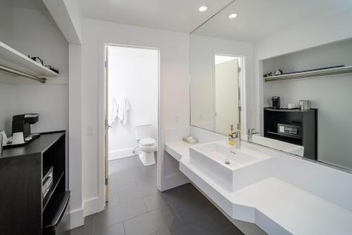 旧金山贝克汽车旅馆的白色的浴室设有水槽和镜子