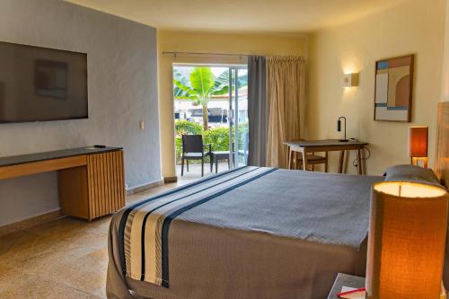 巴亚尔塔港Friendly Fun Vallarta Different Experiences的酒店客房设有一张大床和一个阳台。