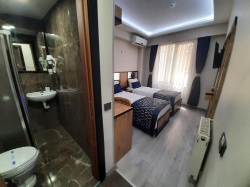 伊斯坦布尔Vizyon Hotel的浴室设有一间卧室,配有一张床和一个水槽