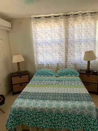 基督教堂市海风公寓的一间卧室配有一张带绿床罩和两盏灯的床。