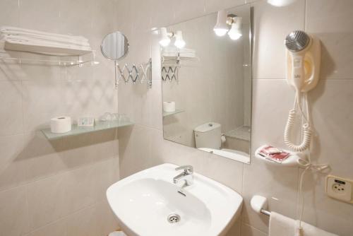 桑亨霍卡里布萨克森酒店的白色的浴室设有水槽和电话