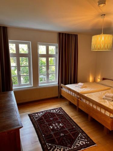 代特莫尔德Ferienwohnungen Café Cup的一间卧室设有两张床、两个窗户和地毯。
