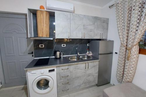 伏罗拉villa Heljos apartaments的厨房配有水槽和洗衣机