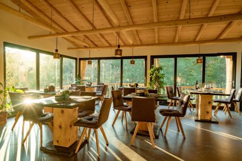 Gura TeghiiOM Resort的餐厅设有木桌、椅子和窗户。
