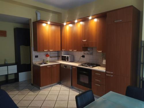 布雷索Intero appartamento a Nord di Milano的厨房配有木制橱柜和炉灶烤箱。