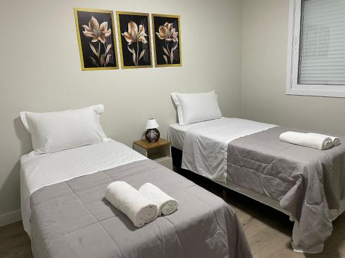 新彼得罗波利斯Aconchego na Serra - Nova Petrópolis的配有2张床的客房内配有白色床单和毛巾