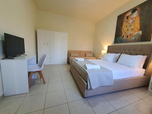 科斯镇Livas City Relaxing Apartment的一间卧室配有一张床、一张书桌和一台电视