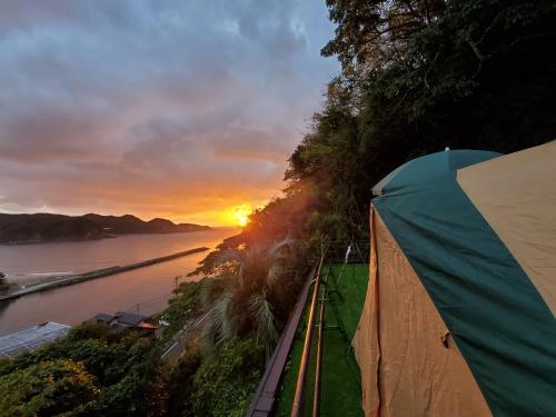 南伊豆町手石キャンプ場的河边的帐篷,享有日落美景