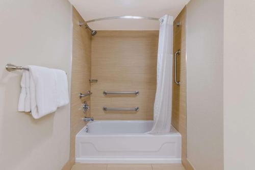 纳格斯黑德南海滨康福特茵酒店的带淋浴的浴室配有白色浴缸。