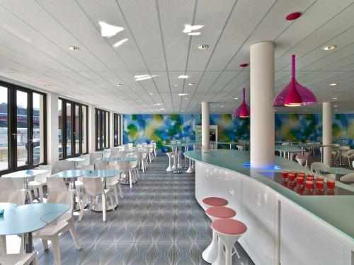 汉堡汉堡城普利泽特酒店的餐厅设有酒吧和桌椅
