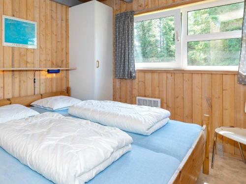 图鲁普斯特兰德Three-Bedroom Holiday home in Fjerritslev 21的配有木墙和窗户的客房内的两张床