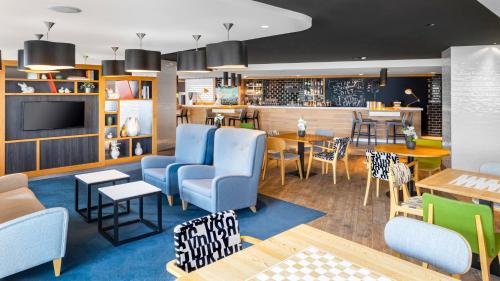 阿姆斯特丹竞技场塔阿姆斯特丹假日酒店的一间设有蓝色椅子的餐厅和一间用餐室