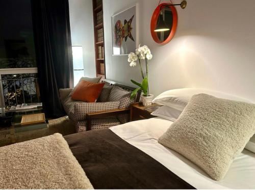圣克鲁斯-德特内里费Niko Rooms的一间卧室配有一张床,客厅配有椅子