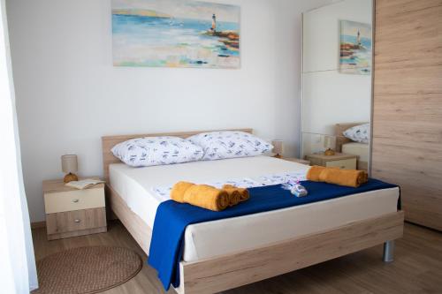 沃迪切Villa Koraljka的一间卧室配有蓝色和白色床单