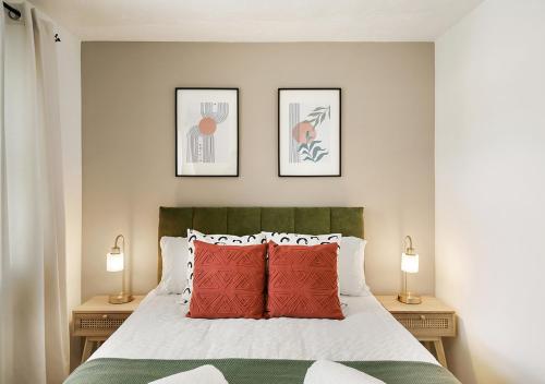 伦敦East London House near tube with parking的一间卧室配有一张带红色枕头的床和两盏灯。