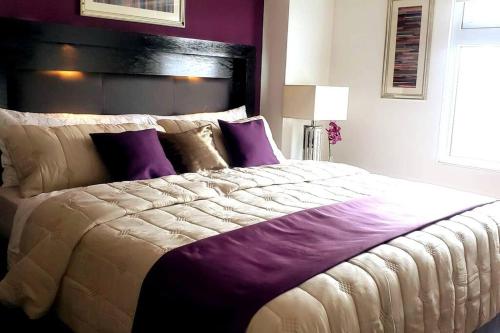 危地马拉Torre Pamplona 409 -Nuevo y Cómodo- Apartamento的一间卧室配有一张带紫色枕头的大床