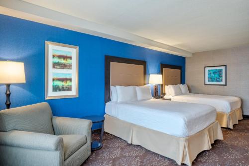 特雷霍特特雷霍特假日酒店&度假村的酒店客房,配有两张床和椅子