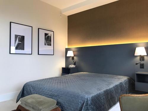 圣保罗Q-Flat Hotel - Faria Lima的卧室配有一张床,墙上挂有两张照片
