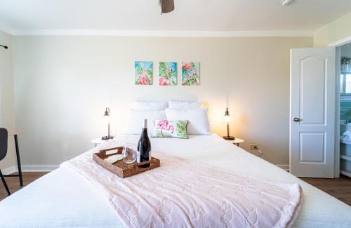 巴拿马城海滩Renovated Studio - Steps to Beach, POOL, & Cabana!的一张白色的床,上面有一瓶葡萄酒