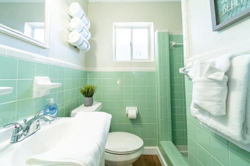 巴拿马城海滩Renovated Studio - Steps to Beach, POOL, & Cabana!的浴室铺有绿色瓷砖,设有卫生间和水槽。