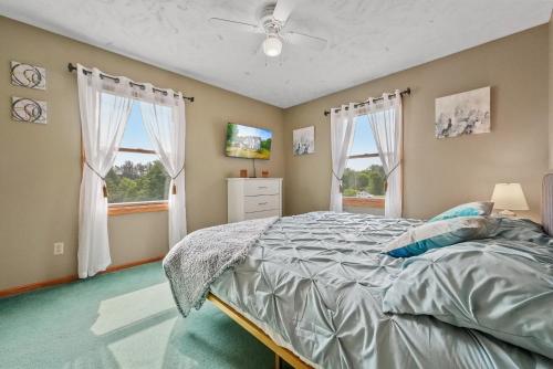 特拉弗斯城LONG LAKE RETREAT- Hot tub, Pool table, Firepit的一间卧室设有一张床和两个窗户。