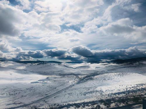 金德拜恩Carinya Village Jindabyne的云层覆盖的雪地的空中景观