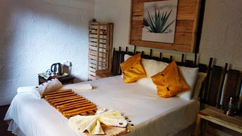 卡萨内Elephant Trail Guesthouse and Backpackers的卧室配有一张带黄色枕头的大型白色床。