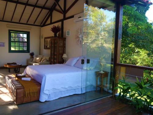蒂拉登特斯Lofts Villa da Serra的一间卧室设有一张床和玻璃墙