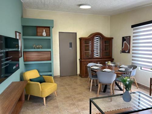 瓦哈卡市Xochimilco Apartment的一间带桌子的客厅和一间餐厅