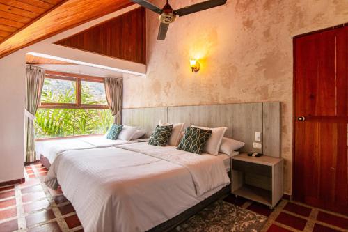 CalabazoPortales del Tayrona Garden Hotel的一间卧室设有两张床和窗户。