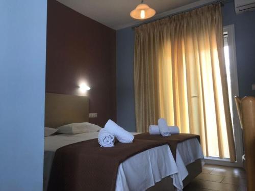 普里诺斯Tasos Rooms的酒店客房,配有两张带毛巾的床