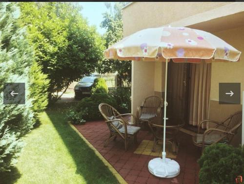 斯特鲁加Lake apartments的一个带桌子和遮阳伞的庭院