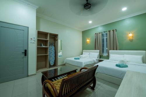 马六甲Villa Dracaena Melaka With Swimming Pool, Hill View and 20 minutes to Town的一间带两张床和一张沙发的客厅