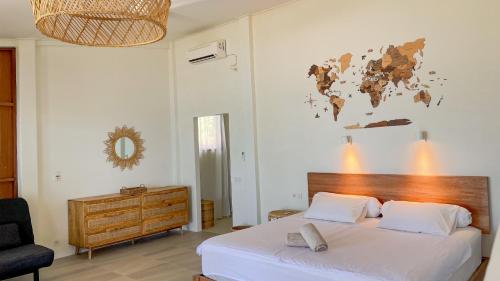 沙璜Sunset Beach Resort Weh的一间卧室配有一张床,墙上挂着一张世界地图