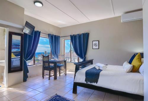 巴利托Ocean View Villas的卧室配有一张床和一张桌子及椅子