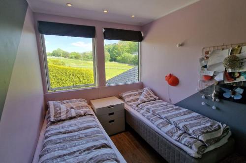卑尔根Luxurious villa at Troldhaugen的一间卧室设有两张床和窗户。