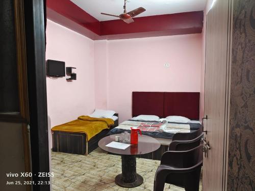 勒克瑙Sudha sadan的小房间设有桌子和床