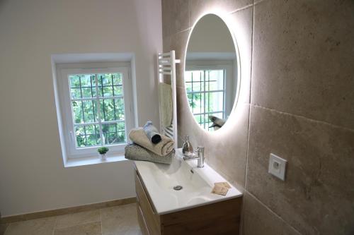 佩尔蒂La Bastide au coeur de la Provence的一间带水槽和镜子的浴室