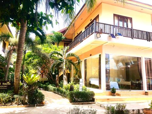 哈林海滩Family House Resort, Haad Rin的前面有棕榈树的房子