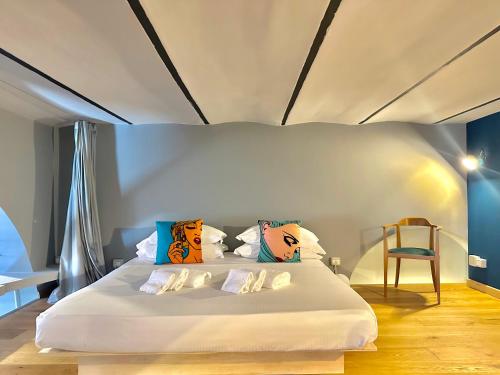 罗马Trastevere Loft的卧室配有白色的床和色彩缤纷的枕头