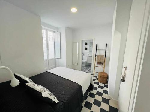 麦地那西多尼亚Casa Las 4 Esquinas by Casas con Encanto的一间卧室设有一张黑色的床和一张 ⁇ 床