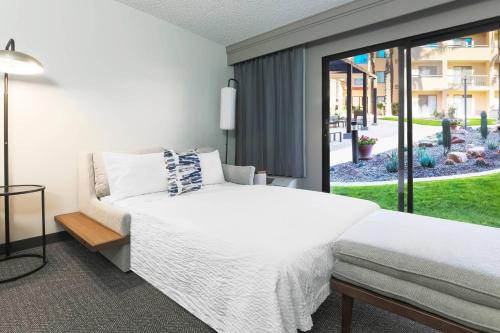 土桑图森机场万怡酒店的一间卧室设有一张床和一个大窗户