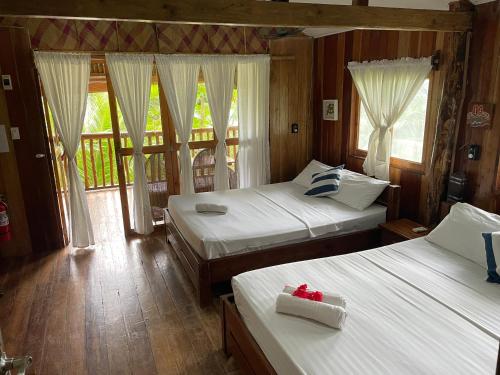 Buruanga白沙滩前别墅的一间带两张床的卧室和一个阳台