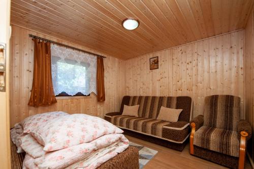 斯图托沃Domki, pokoje u Małgosi的一间卧室配有一张床、一张沙发和一把椅子