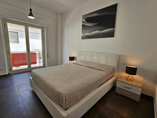 维博瓦伦蒂亚码头Residenza Atena的一间白色卧室,配有一张床和两盏灯
