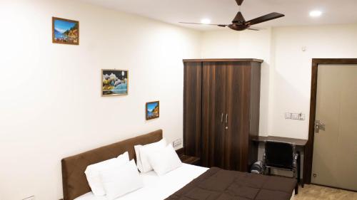 印多尔Hotel Kiwi Inn的一间卧室配有一张床和吊扇