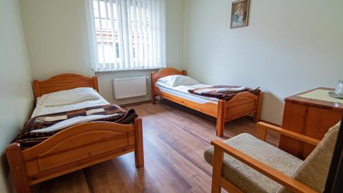 科沙林Dom Rekolekcyjny CEF Koszalin的铺有木地板的小客房内的两张床