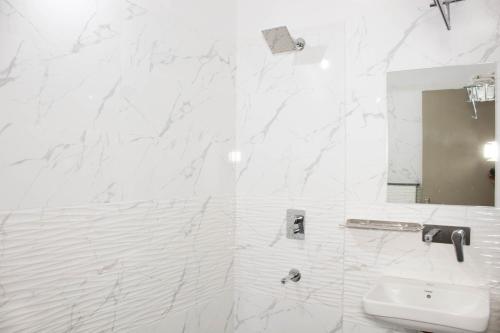 印多尔Hotel Kiwi Inn的白色的浴室设有水槽和镜子