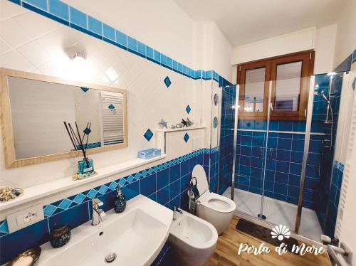 皮昂比诺Appartamento Perla di Mare的蓝色瓷砖浴室设有卫生间和水槽
